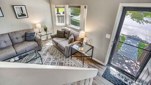 A living room with a sofa, a coffee table, and a glass door leading to a balcony.