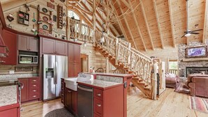 A spacious log cabin interior with a kitchen, dining area, and living room. - Powdermill Hill Cabin 3 Bedroom Cabin by RedAwning (Gatlinburg)