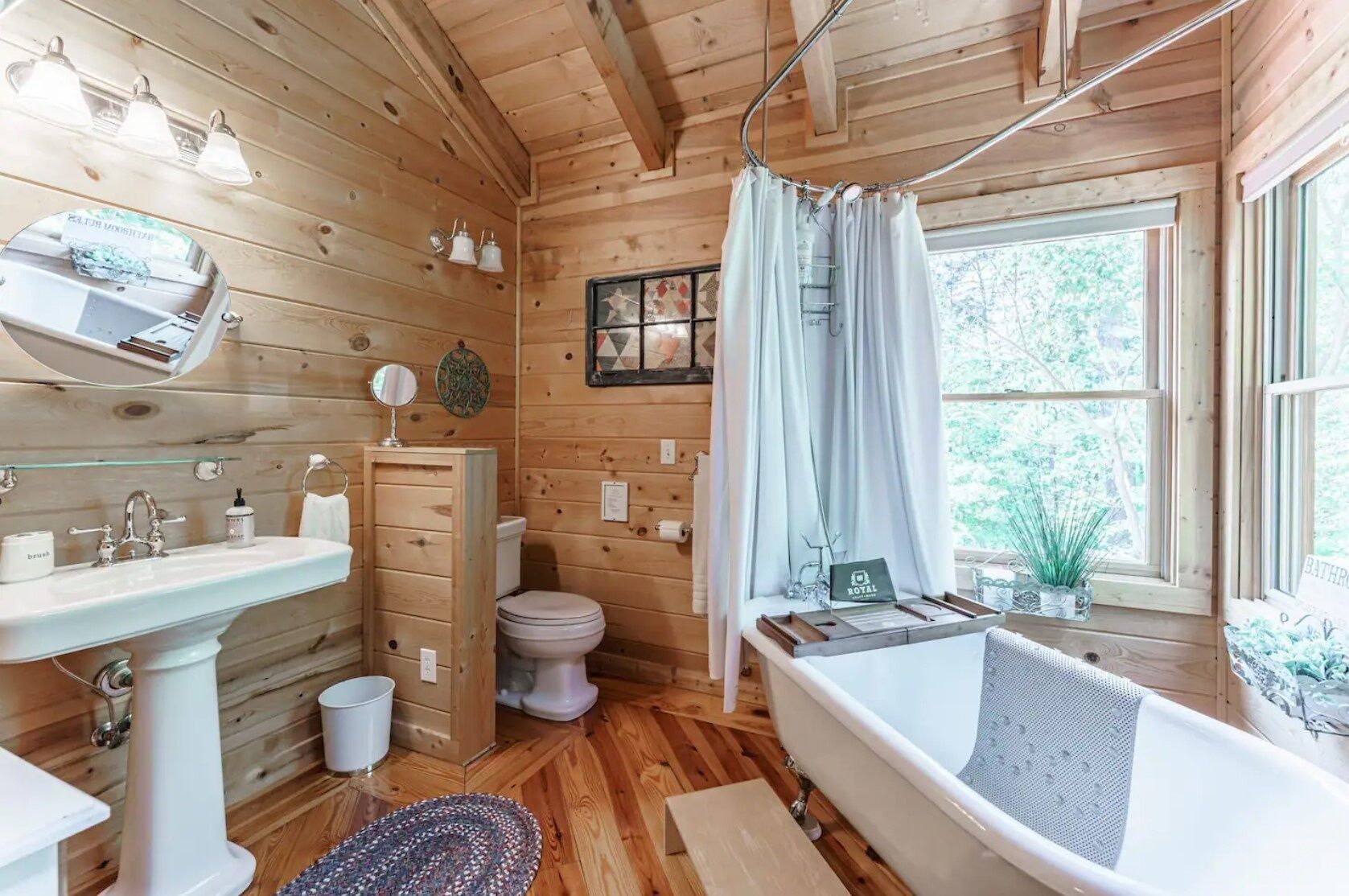 A wooden cabin bathroom with a sink, toilet, and bathtub.
