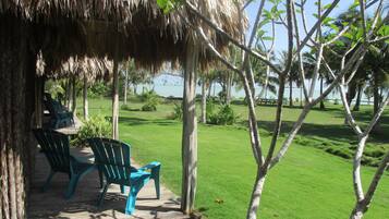 Relax in a serene outdoor space surrounded by lush greenery and a tranquil body of water.