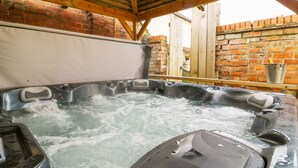 A hot tub with a wooden roof and brick walls. - Well Cottage (Beverley)