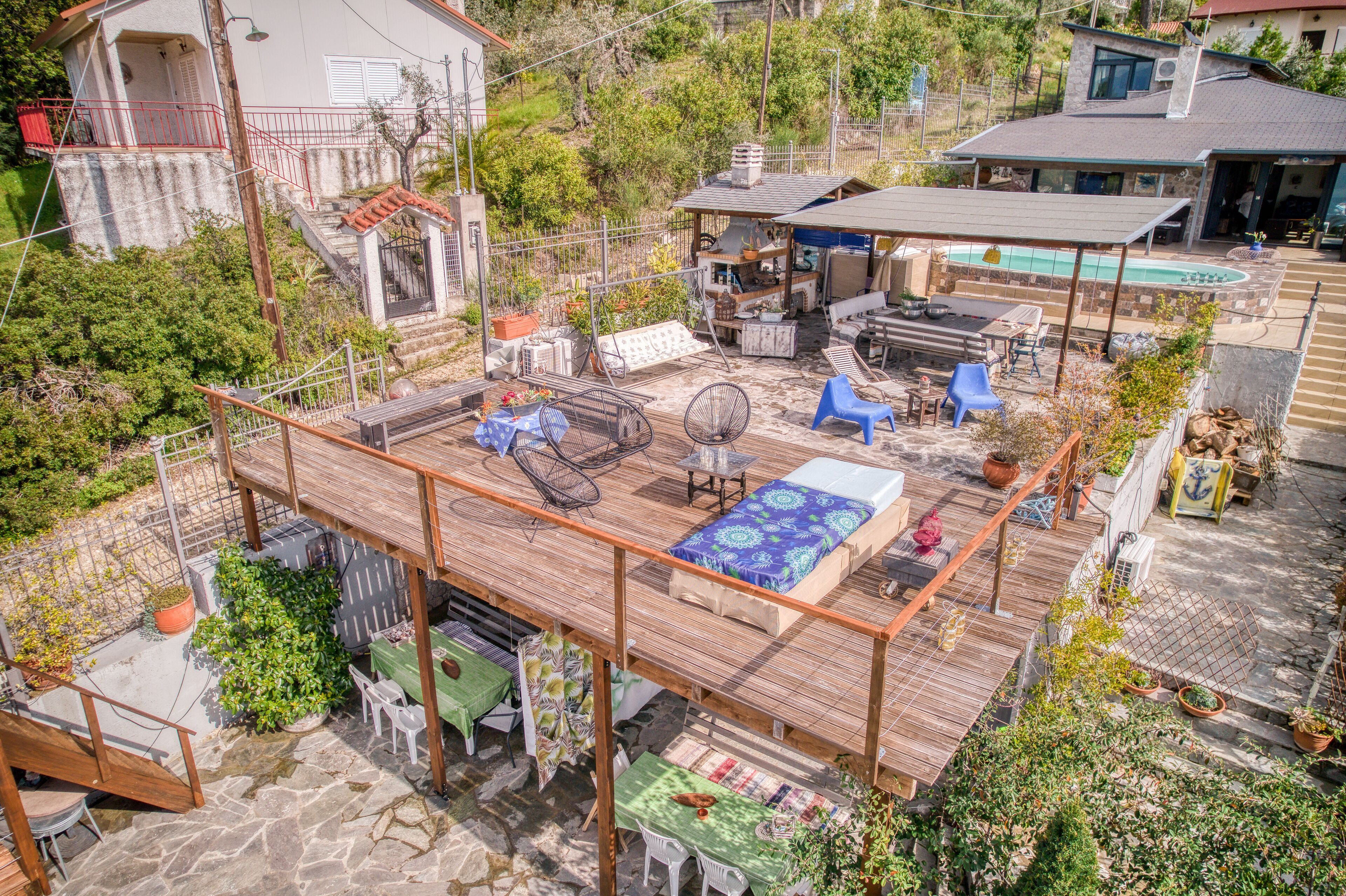 Um terraço no telhado com mobiliário de exterior, piscina e área coberta com churrasqueira.