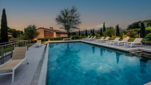 A swimming pool with lounge chairs and a building in the background.
