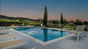 A rooftop pool with lounge chairs and a view of the surrounding landscape.