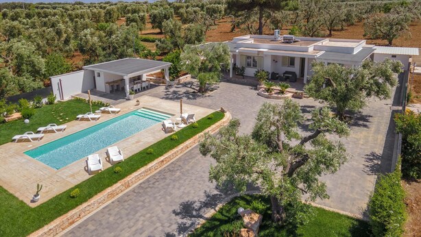 Une villa moderne dotée d’une piscine, d’un espace extérieur aménagé et d’un jardin paysager.