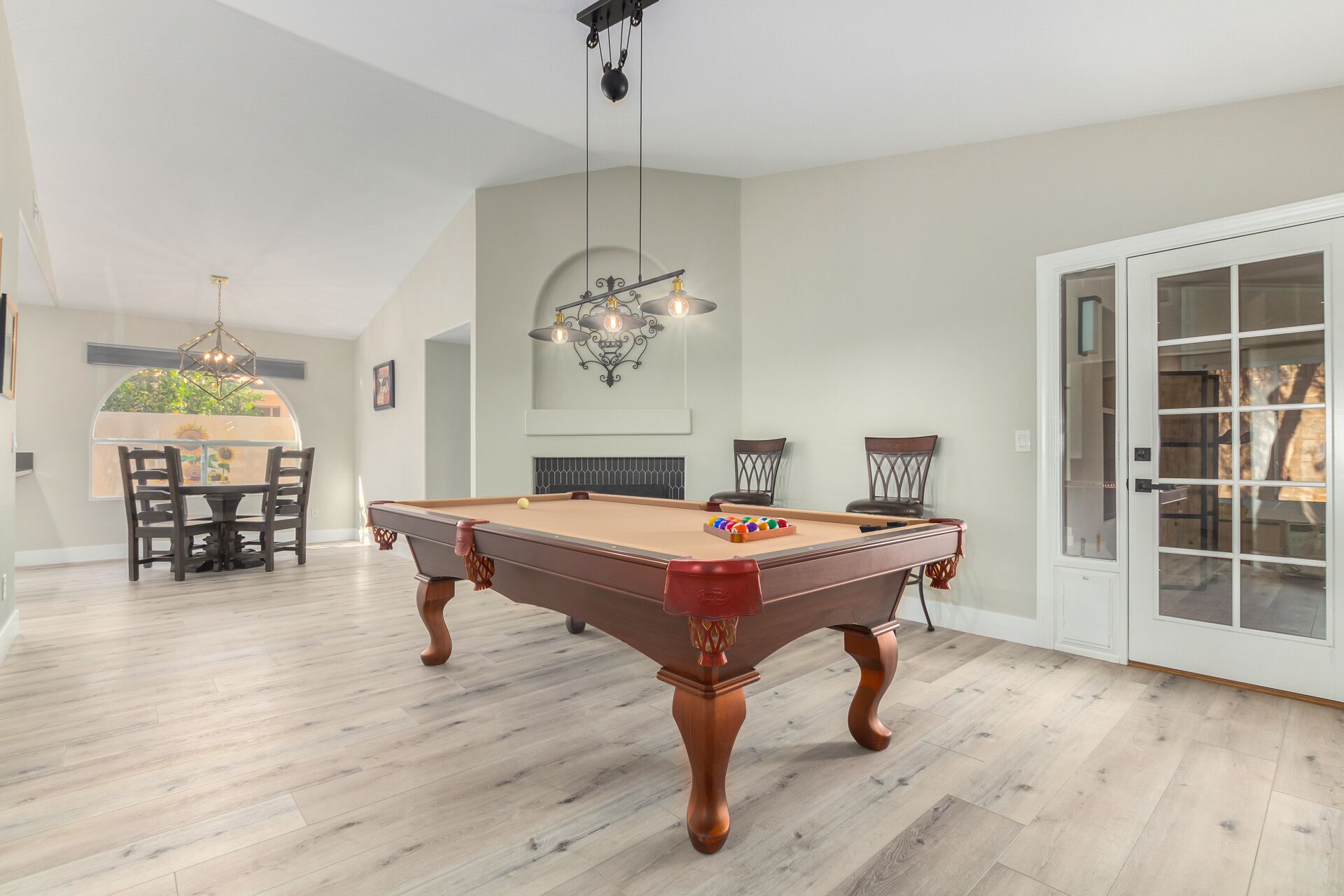 A spacious room with a pool table, a dining area, and a fireplace. - Cozy 2 bedroom house in Chandler (Chandler)