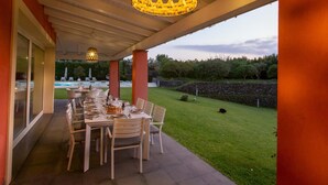 An outdoor dining area with a table set for six, overlooking a swimming pool and a stone wall. - Villa Chimia 8 (Acireale)