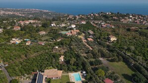 An aerial view of a residential area with houses, a swimming pool, and a solar panel installation. - Villa Chimia 8 (Acireale)