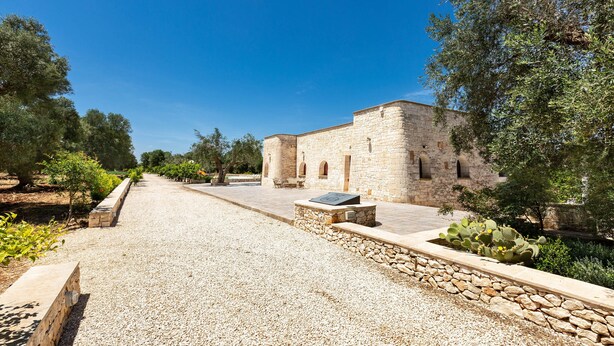 A historic stone building with a gravel pathway and cacti. - 1963 Villa Ajeni by Perle di Puglia (San Michele Salentino)