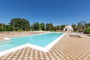 A rectangular swimming pool with a tiled deck, surrounded by lounge chairs and a stone wall. - 1963 Villa Ajeni by Perle di Puglia (San Michele Salentino)