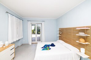 A bedroom with a bed, a dresser, a window with curtains, and a view of the outdoors. - 3030 Villa Meridia- Bilocale by Barbarhouse (Vico del Gargano)