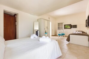 A hotel room with a bed, a desk, a chair, a wardrobe, and a window. - 2480 Villa Sessana by Perle di Puglia (Ostuni)