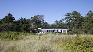A house surrounded by tall grass and trees. - Stunning Ocean View and Private Beach (Nykobing Sjaelland)