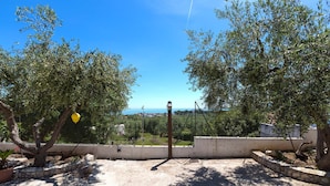 An outdoor area with a concrete floor, a metal gate, and trees providing shade. - 2918 Il Bacio del Sole - Trilocale Matteo by Barbarhouse (Vieste)