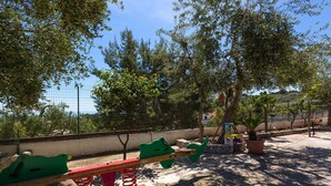 A playground with seesaw and climbing equipment, surrounded by trees and a fence. - 2918 Il Bacio del Sole - Trilocale Matteo by Barbarhouse (Vieste)
