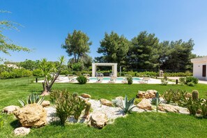 A well-maintained garden with a pool, seating area, and a pergola structure. - 2921 Villa La Seta by Perle di Puglia (San Vito dei Normanni)