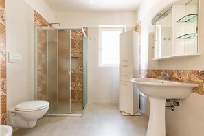 A bathroom with a toilet, shower, sink, and a mirror. - 2921 Villa La Seta by Perle di Puglia (San Vito dei Normanni)