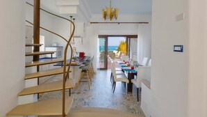 Een modern interieur met een wenteltrap, een eetgedeelte met uitzicht en een keuken met uitzicht.