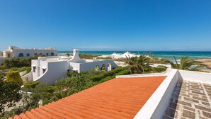 A coastal hotel with white buildings, a red-tiled roof, and a view of the beach and ocean. - 2374 Villa Costa Merlata by Perle di Puglia (Ostuni)