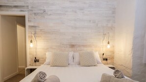Ein Hotelzimmer mit einem großen Bett, zwei Nachttischen und einem hölzernen Kopfteil.