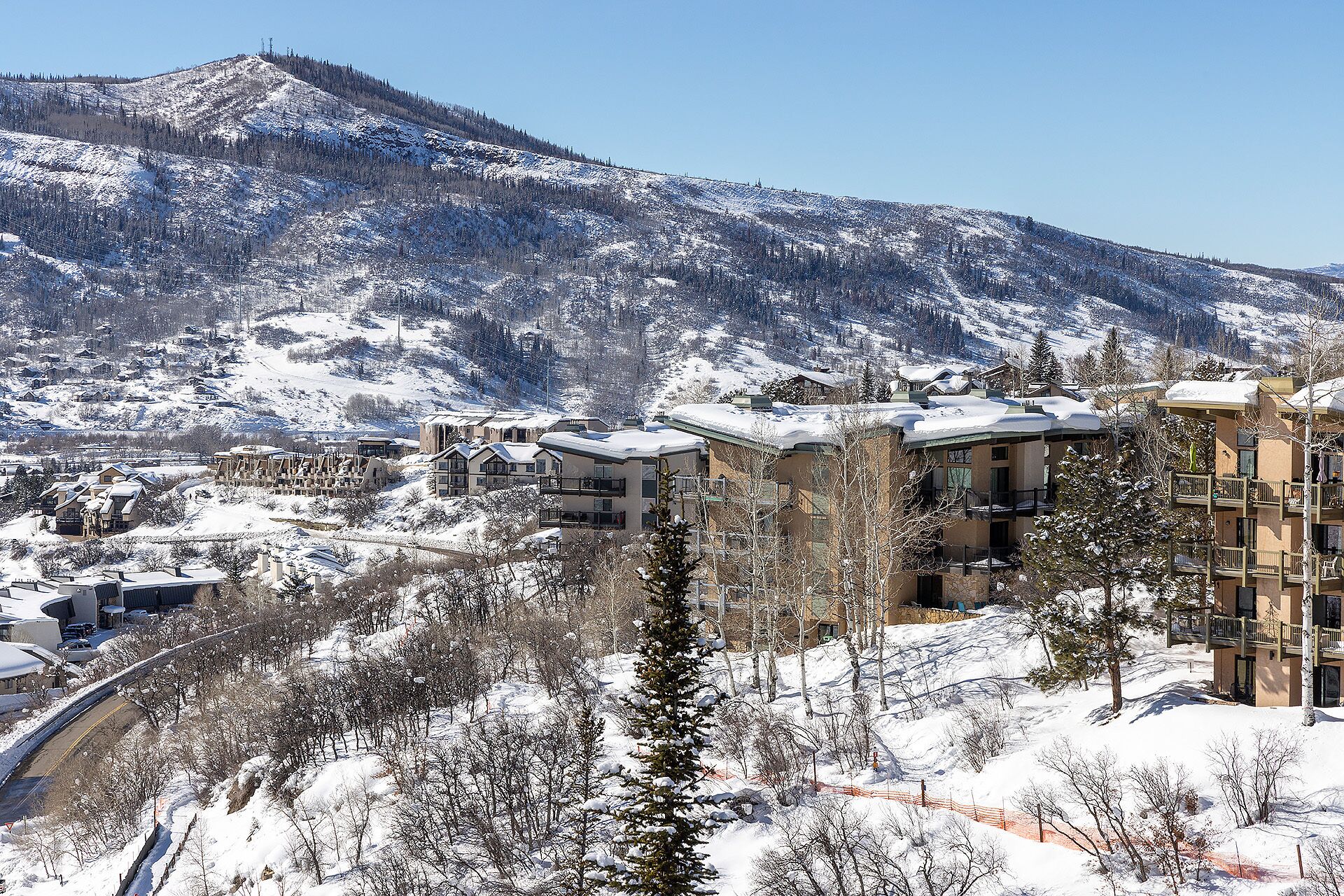 Une montagne enneigée, avec une station de ski en arrière-plan.