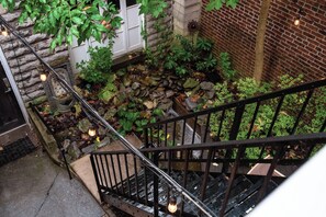 Staircase leads to a serene water feature surrounded by lush greenery.