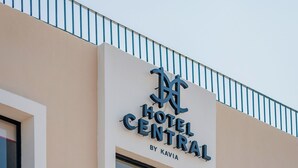 A hotel sign with the name "Hotel Central by Kavia" on a beige building facade. - Hotel Central Merida by Kavia (Mérida)