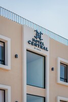 Letrero de hotel con el nombre "Hotel Central by Kavia" en la fachada de un edificio color crema.