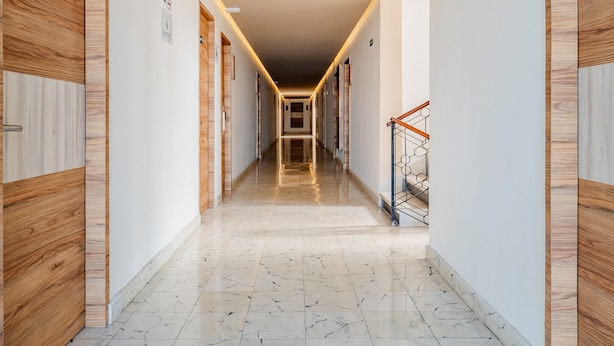 A long, narrow hallway with wooden doors on both sides, a tiled floor, and a staircase at the end. - Hotel Central Merida by Kavia (Mérida)