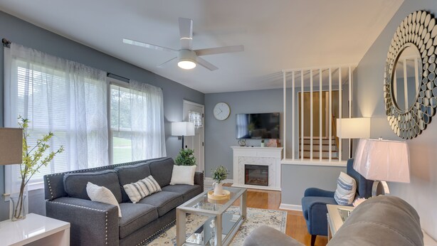 A living room with a grey sofa, a coffee table, a TV, and a fireplace.