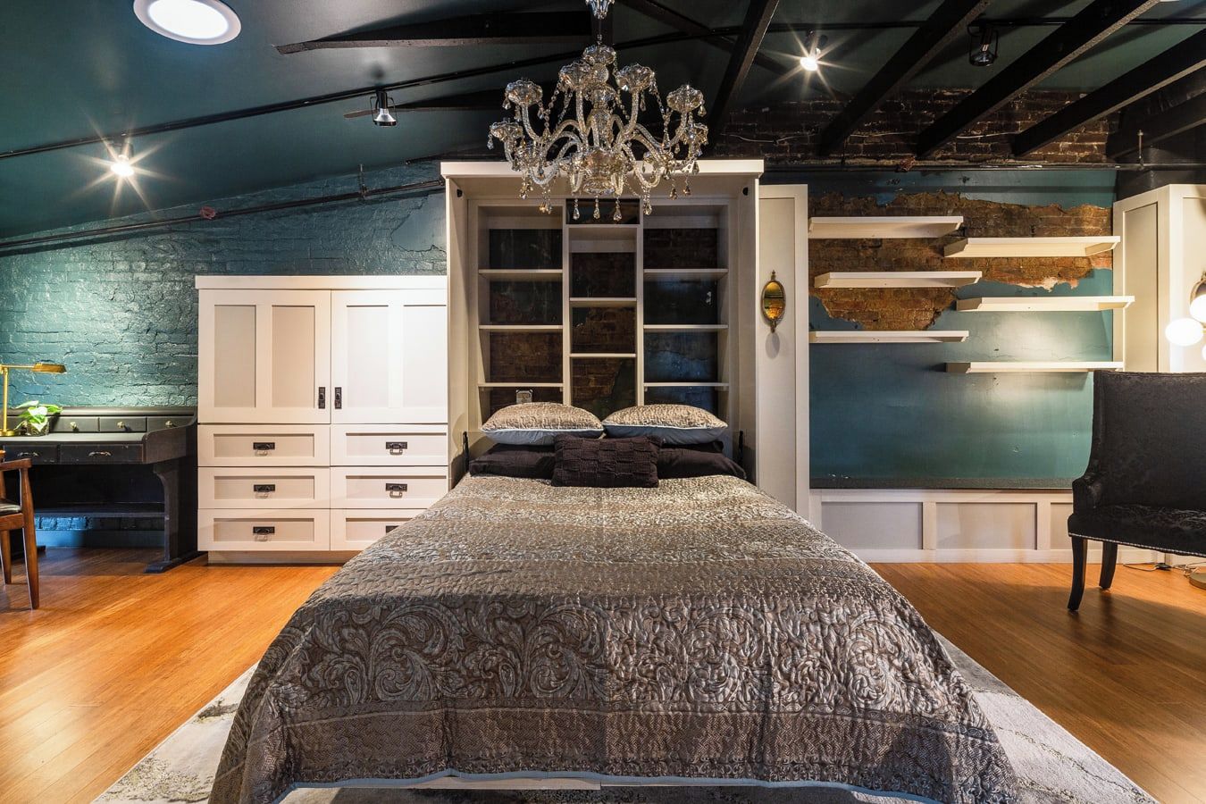 A bedroom with a large bed, a wardrobe, a desk, and a chair.