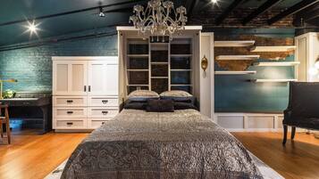 Ein Schlafzimmer mit einem großen Bett, einem Kleiderschrank, einem Schreibtisch und einem Stuhl.