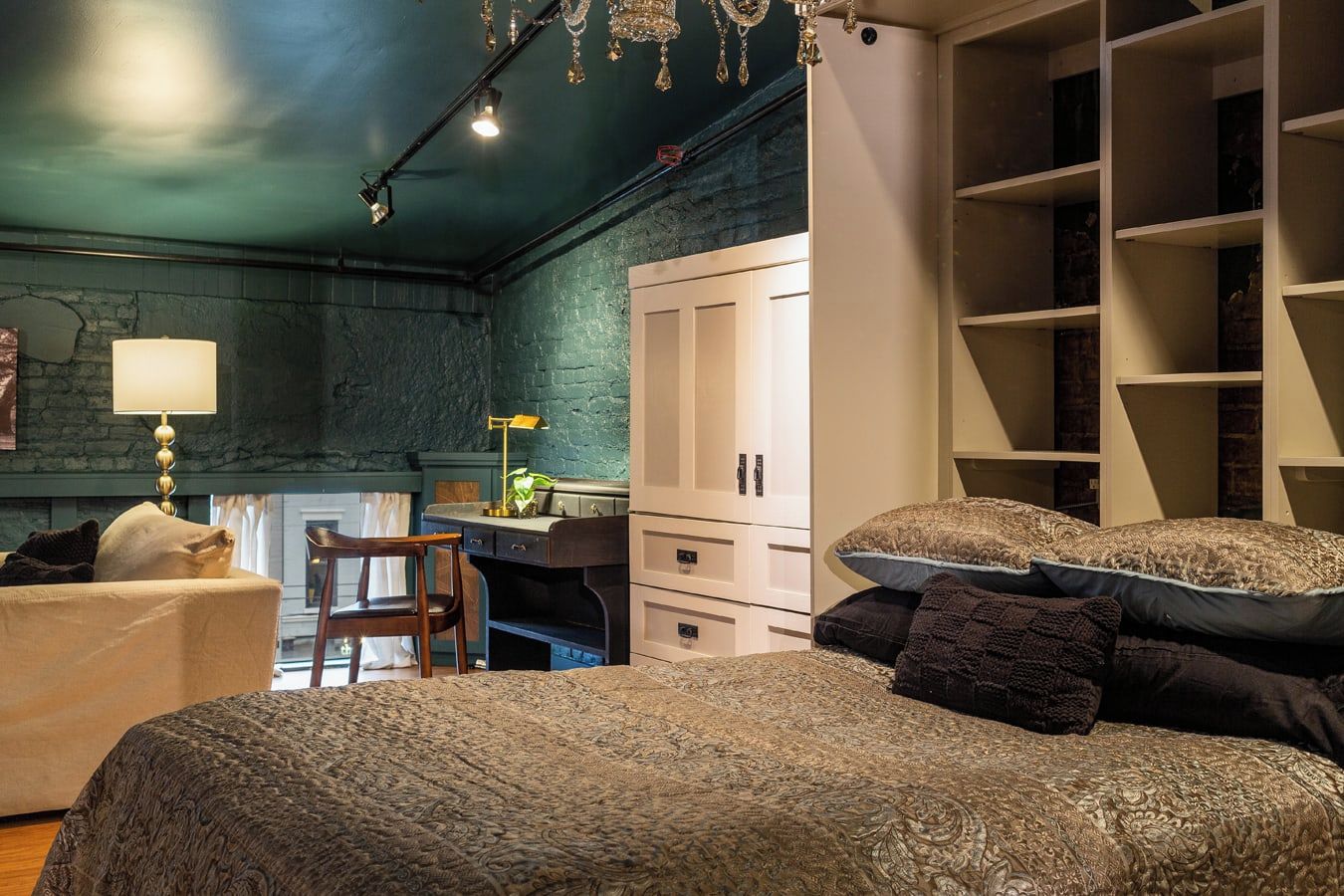 Een slaapkamer met twee bedden, een bureau en een kledingkast.