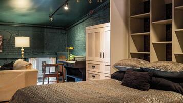 Quarto com duas camas, uma escrivaninha e um guarda-roupa.