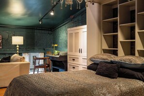 A bedroom with two beds, a desk, and a wardrobe.