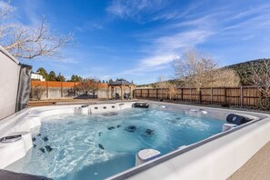 Un jacuzzi con muelle de madera y un pabellón al fondo.