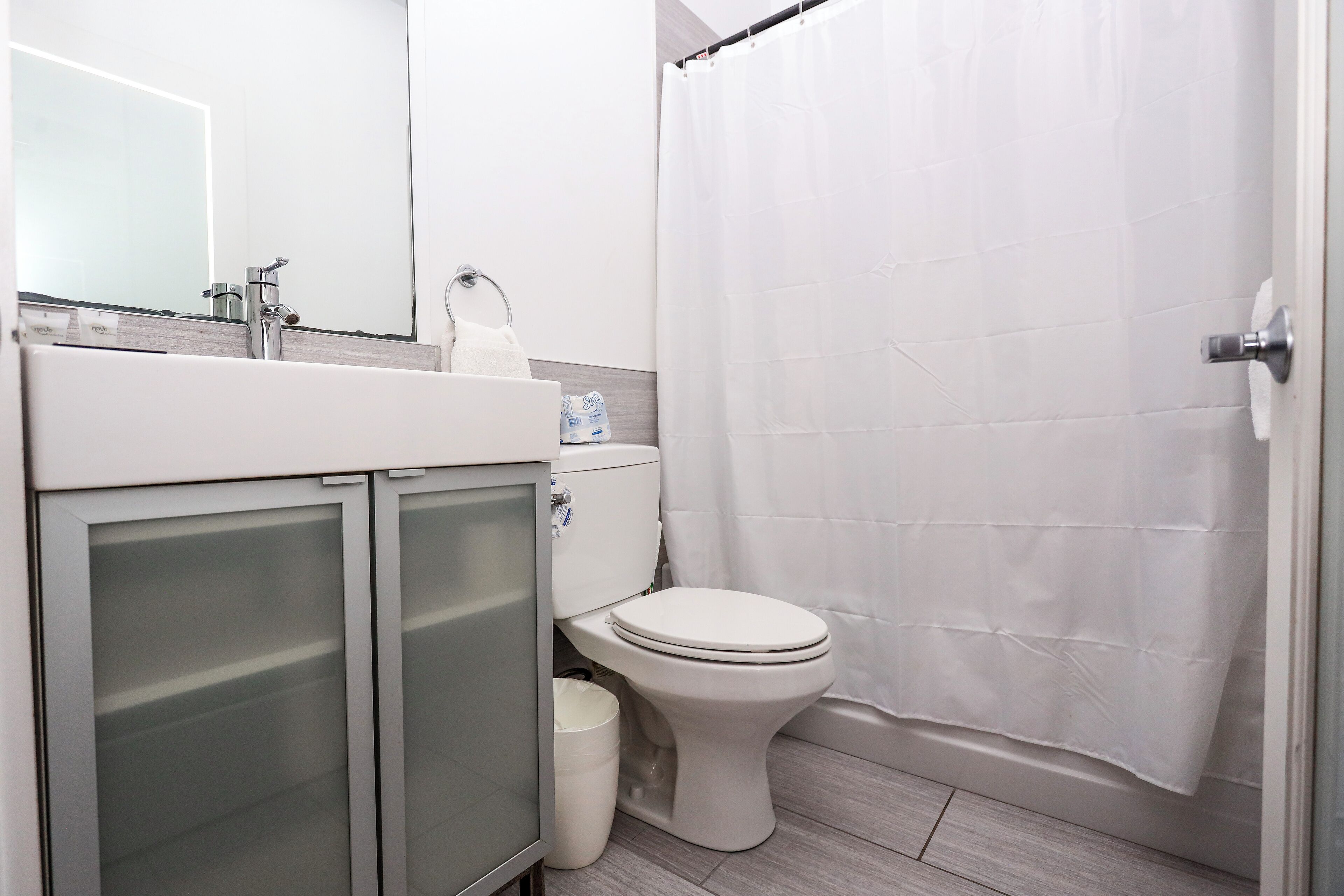Une salle de bain avec des toilettes, un lavabo et un rideau de douche.