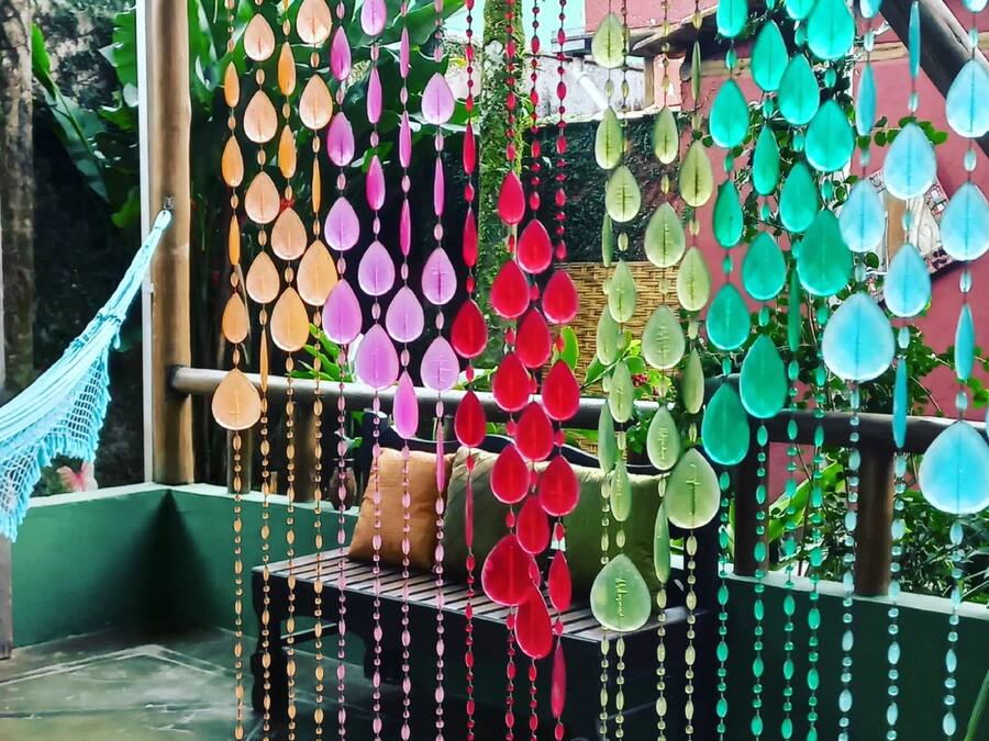 A hammock and a bench with colorful hanging decorations.