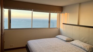 A bedroom with a bed, a window with a view of the sea, and a ceiling light. - Enjoy the terrace and the best sunset and view of the city. (Cartagena de Indias)