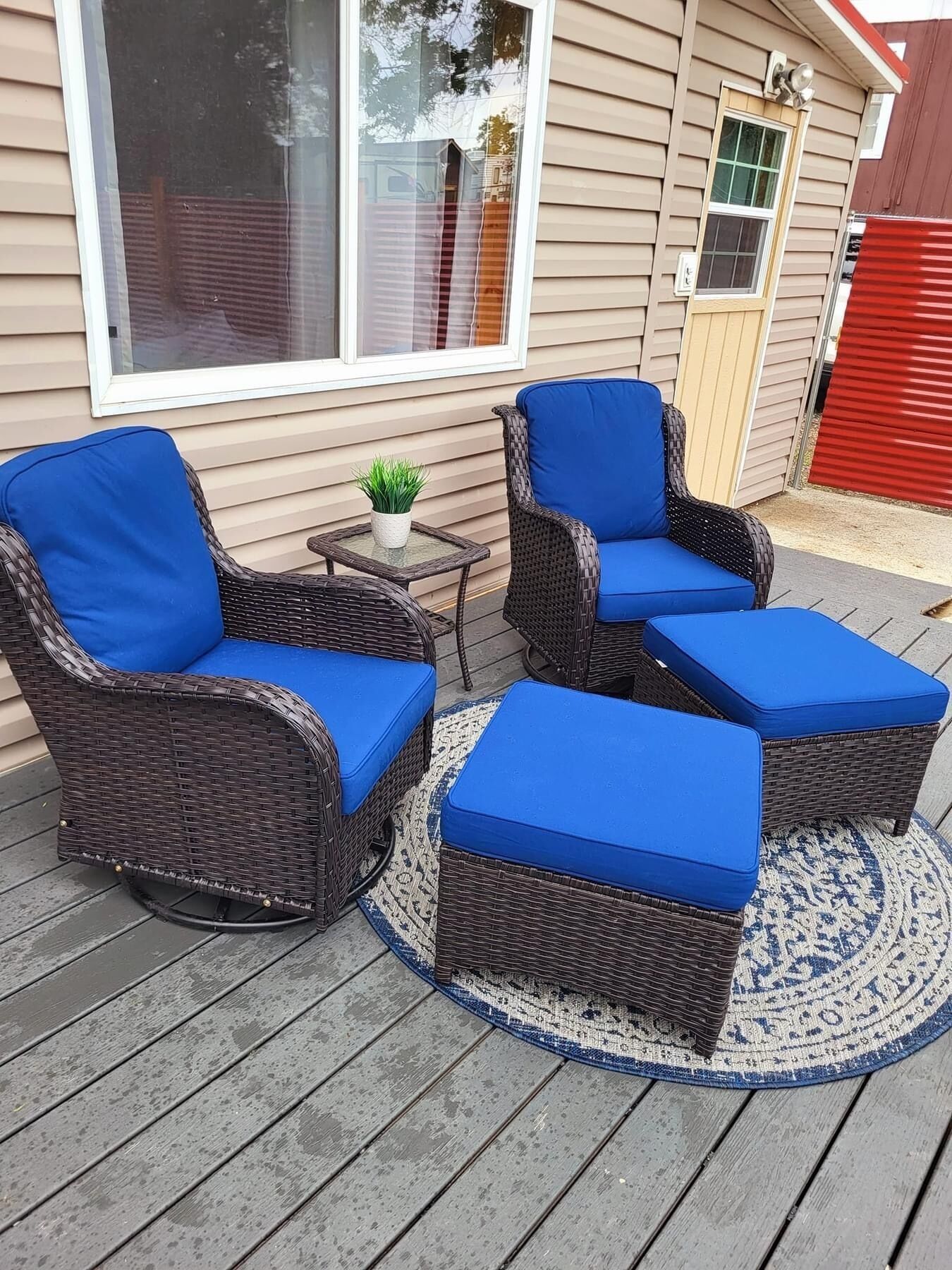 Een terras met rieten meubels en blauwe kussens.