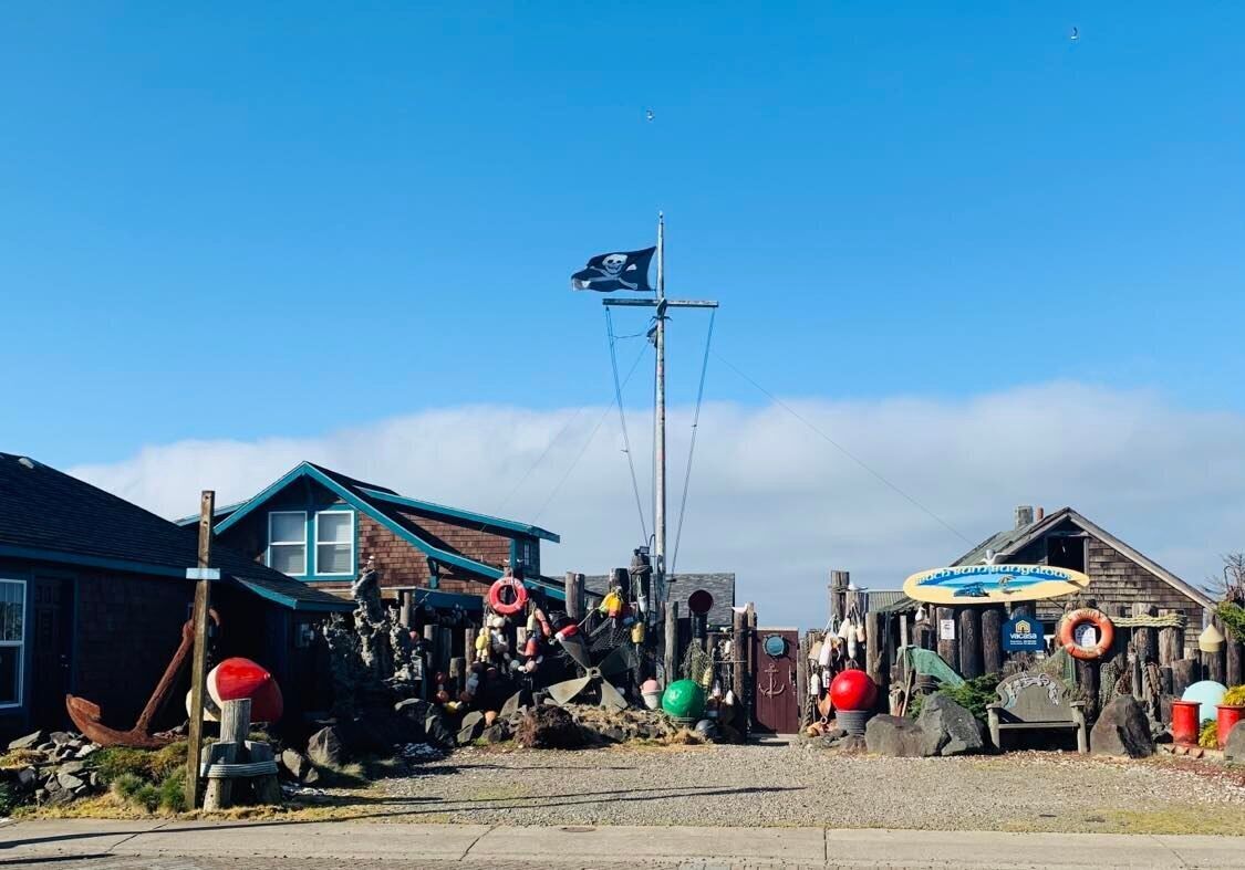 Een kustgebouw met vlag, nautische decoraties en een klein steigergedeelte.