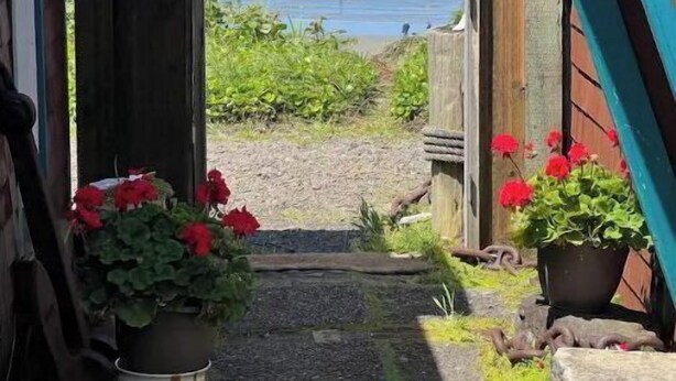 A narrow pathway leading to a beach with a wooden fence and potted plants. - Historic Oceanfront Cottage in Charming Nye Beach (Newport)