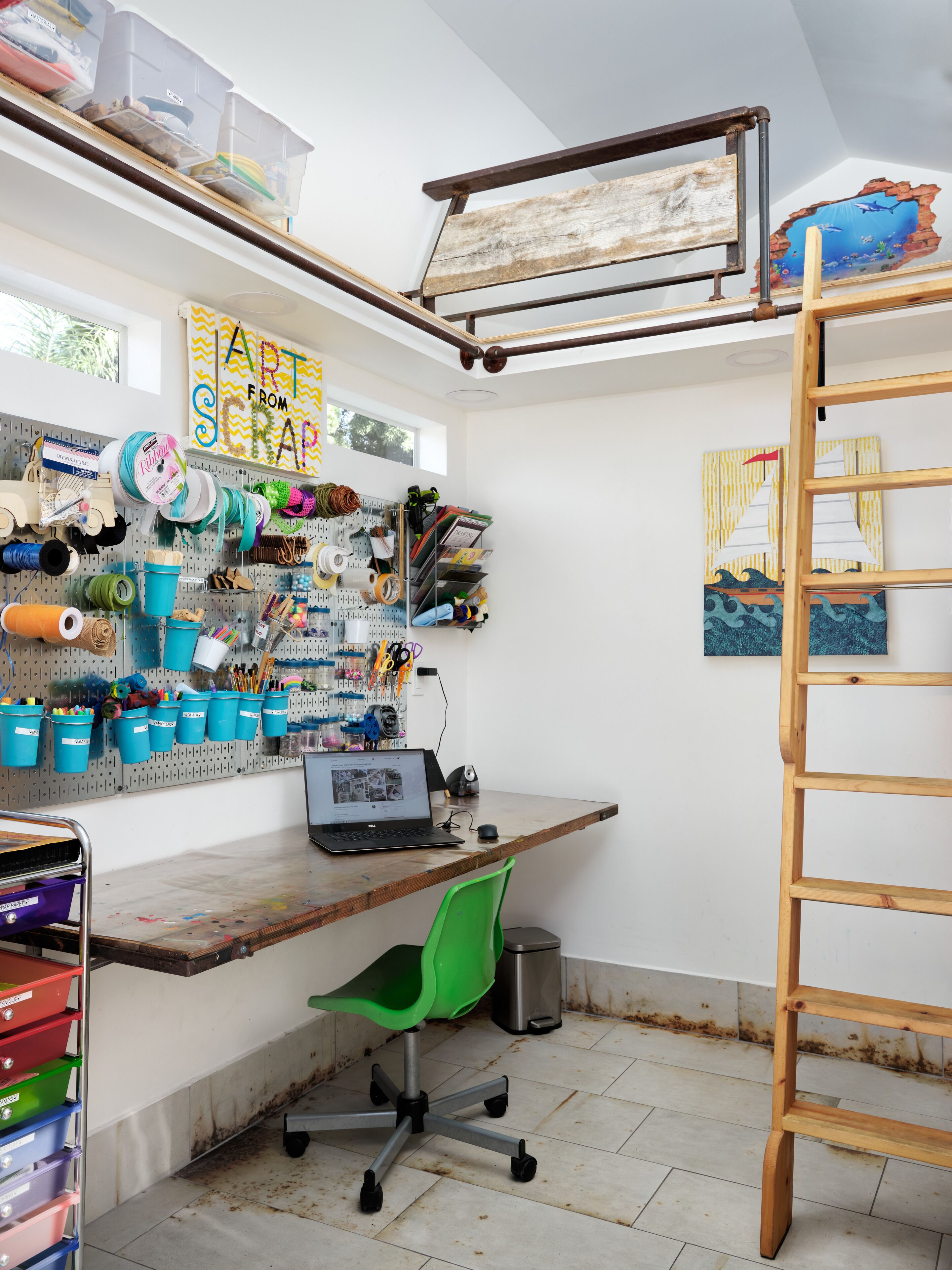 A workspace with a desk, chair, and various craft supplies.