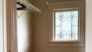 Ein Zimmer mit Holzboden, einem Fenster mit Dekorationsglas und einem Holztisch.