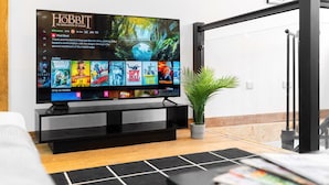 Een flatscreen-tv op een zwarte standaard, waarop een filmselectie wordt weergegeven.