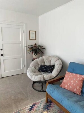 Relax in a cozy room with a comfortable chair and inviting sofa, perfect for unwinding.
