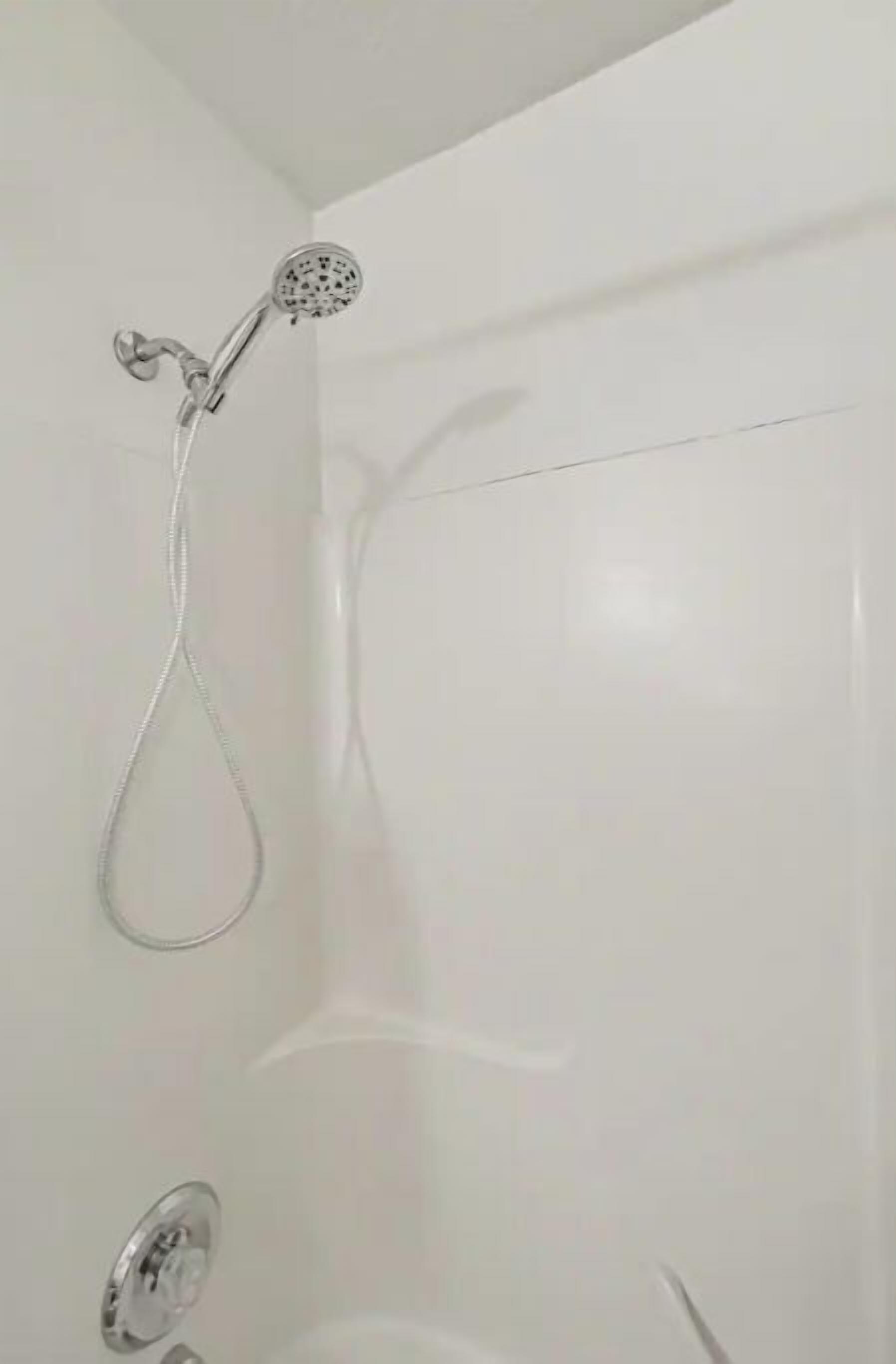 Een badkamer met een douche, toilet en wastafel.