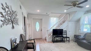 A living room with a dining area, a staircase, and a television. - 1-Min Walk to The Inn • Private Suite, Tub & Full Kitchen. (Washington)