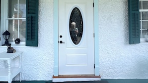 A white door with a decorative glass panel, a black lantern above it, and a white textured wall. - 1-Min Walk to The Inn • Private Suite, Tub & Full Kitchen. (Washington)