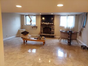Ein Wohnzimmer mit Kamin, einer Bank und einem Bücherregal.